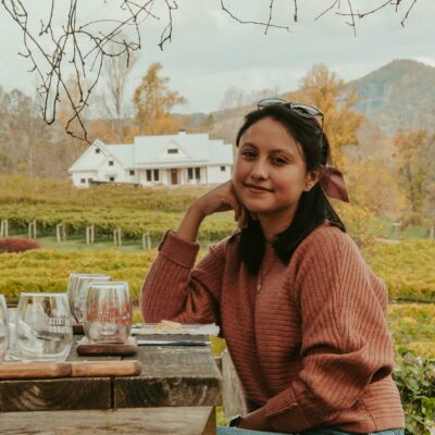 Young woman resting near vineyards in mountainous countryside