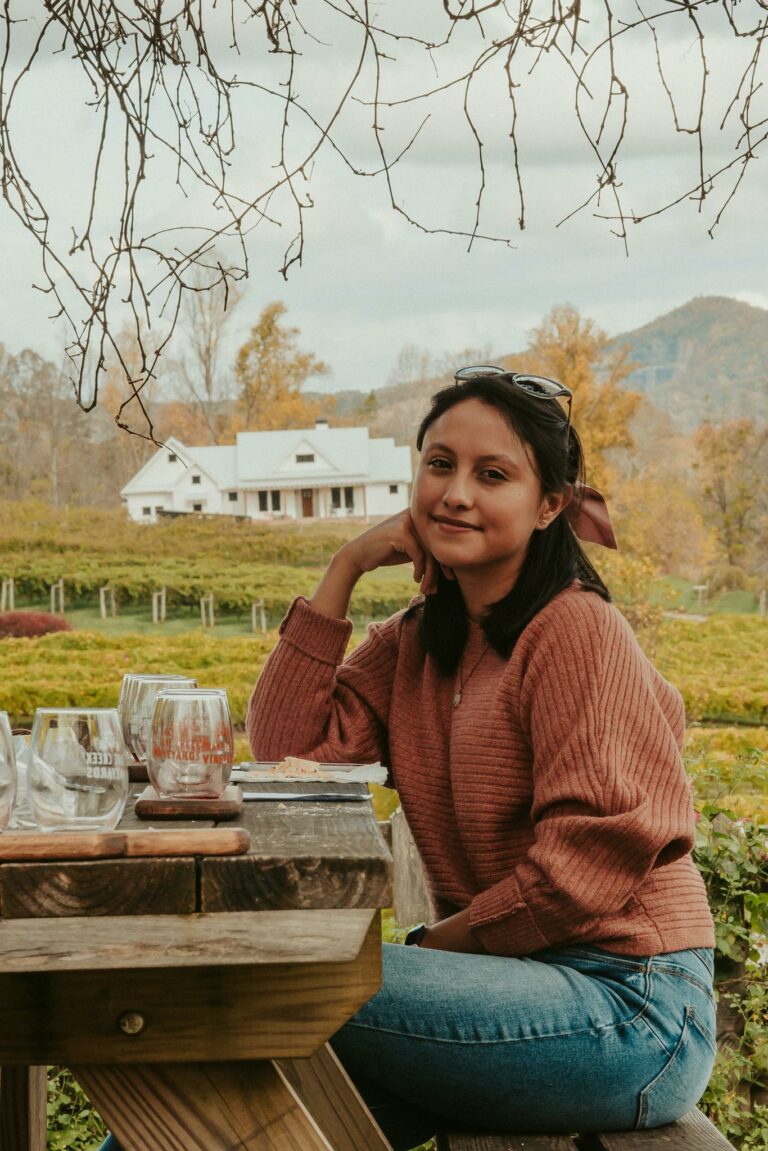 Young woman resting near vineyards in mountainous countryside